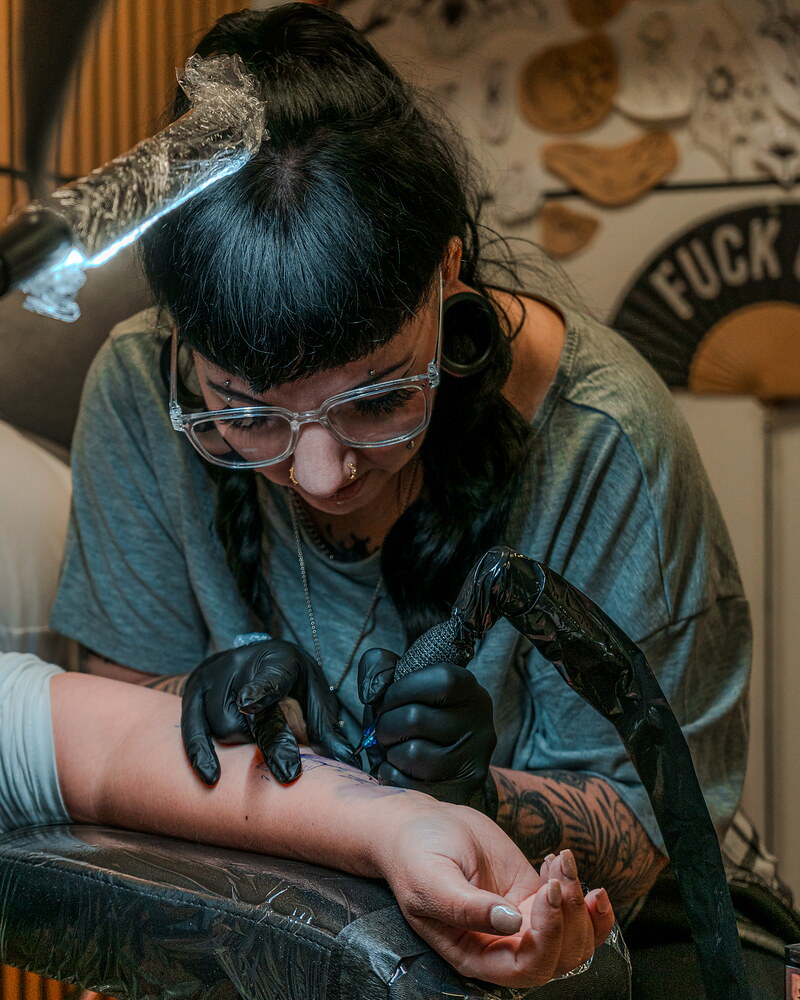 Sophie Guiot, tatoueuse, en plein tatouage d’un avant-bras à The Backrooms Studio, Andenne